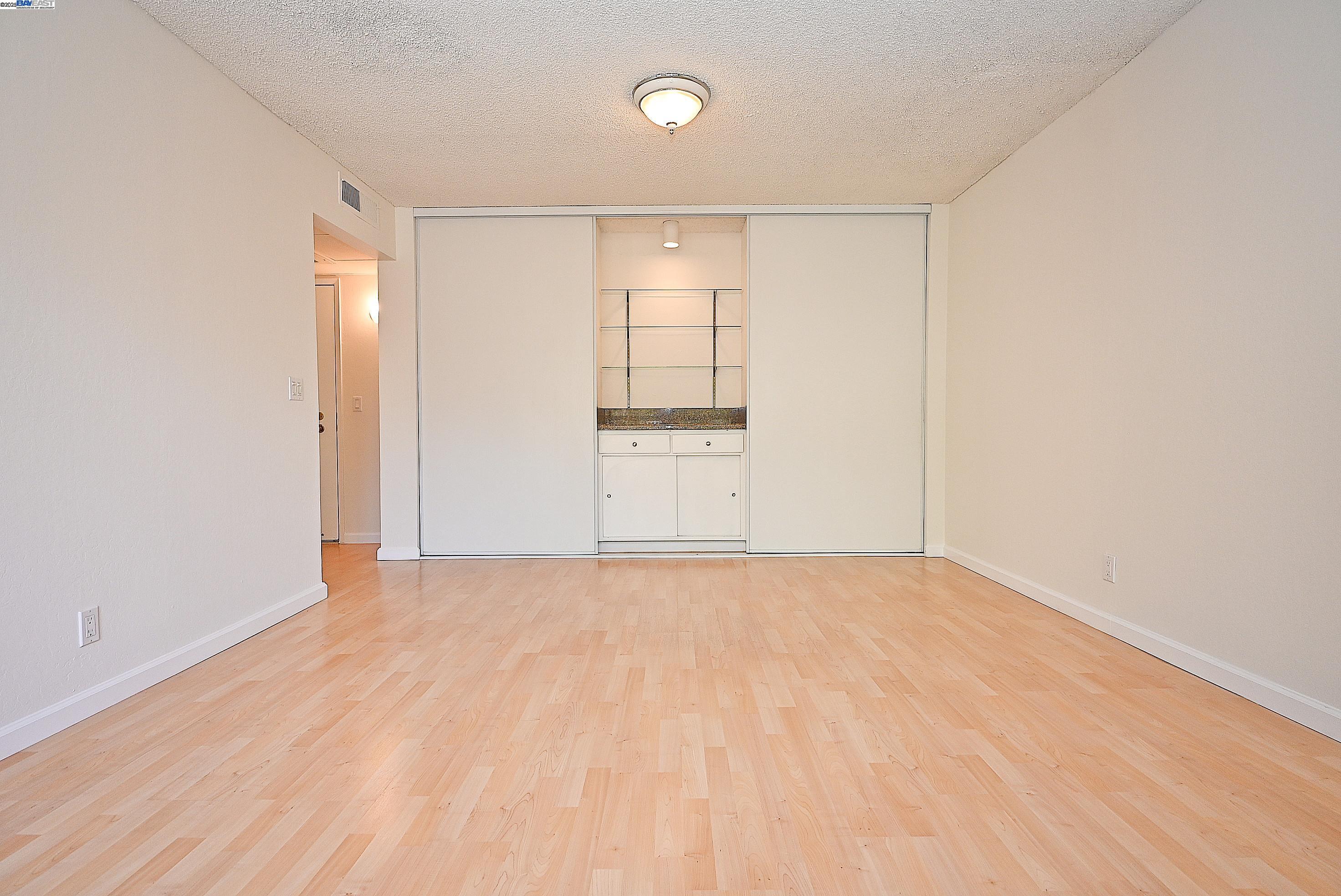 320 North Civic Drive, Unit 307 Walnut Creek, CA 94596 - Photo 12 of 37 a view of an empty room with wooden floor and a window
