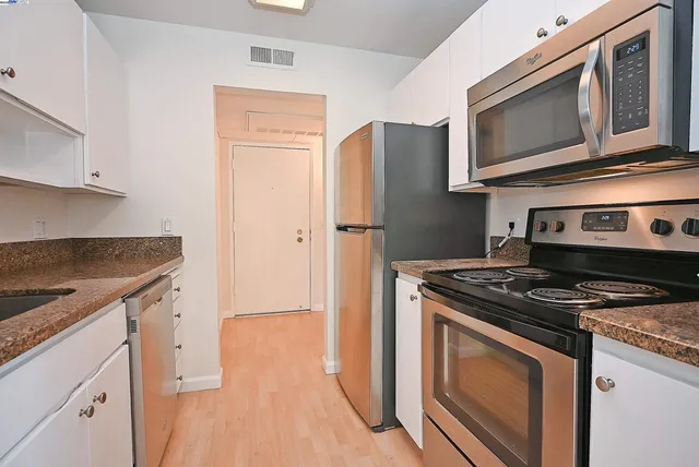 a kitchen with stainless steel appliances granite countertop a stove microwave and refrigerator