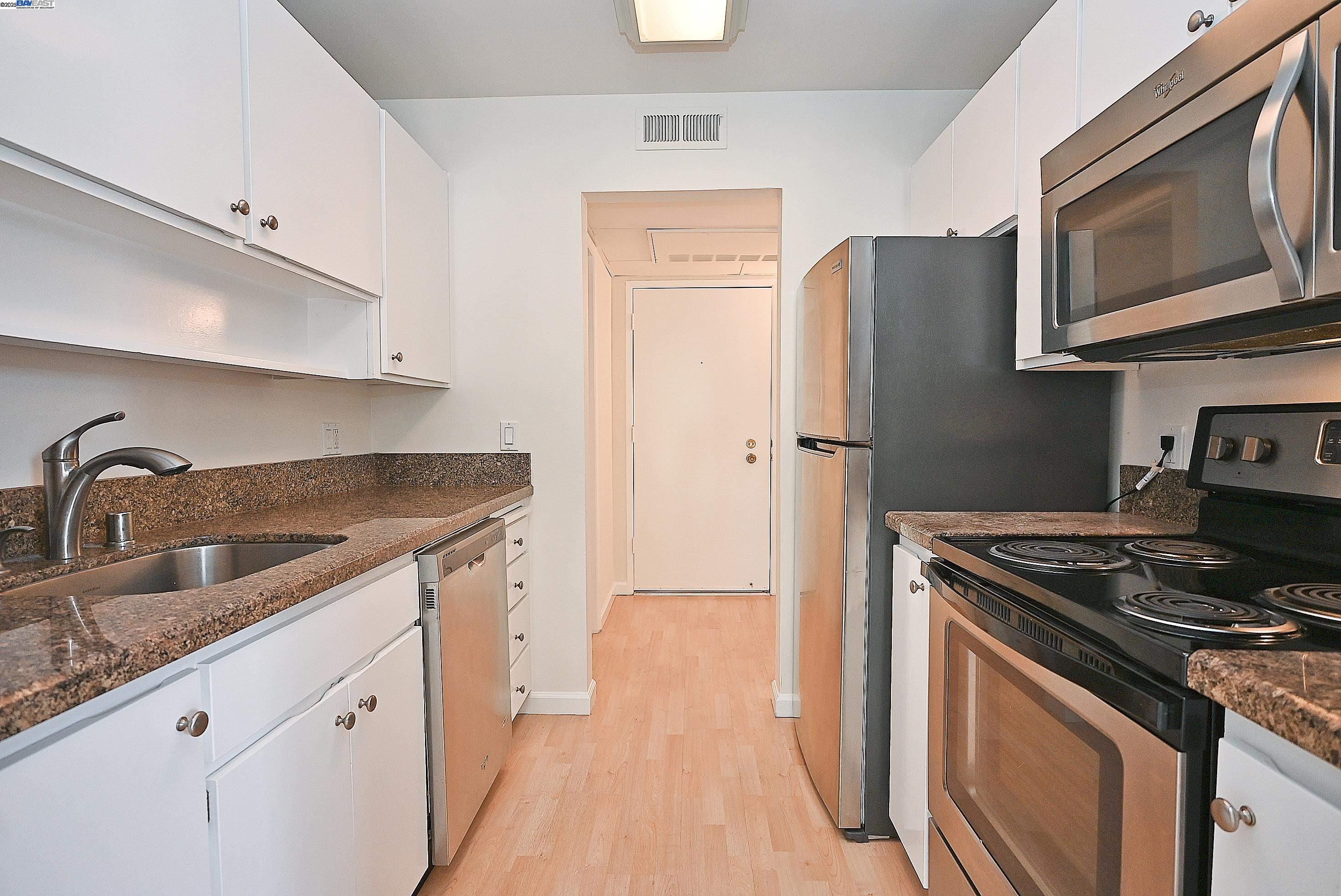 320 North Civic Drive, Unit 307 Walnut Creek, CA 94596 - Photo 14 of 37 a kitchen with stainless steel appliances granite countertop a sink stove and refrigerator