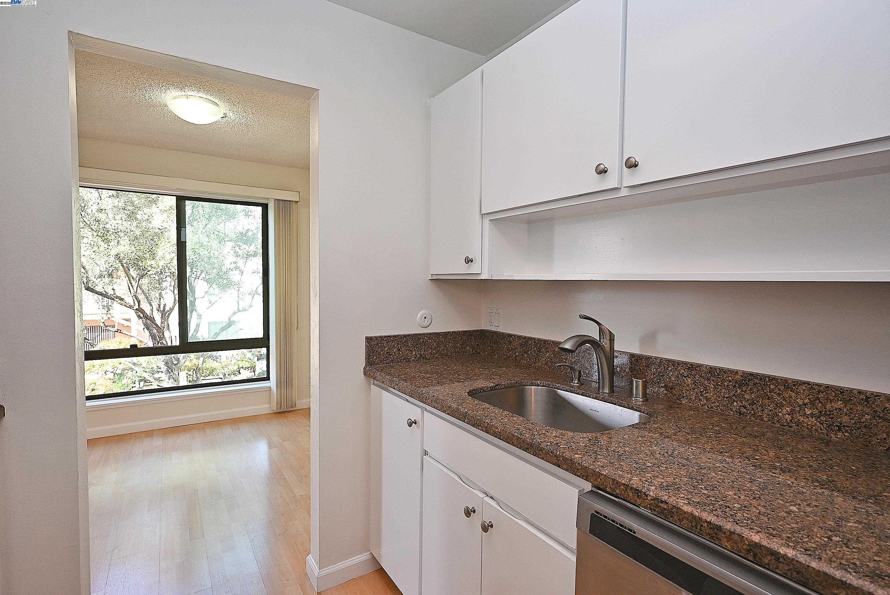 320 North Civic Drive, Unit 307 Walnut Creek, CA 94596 - Photo 15 of 37 a kitchen with granite countertop white cabinets and a sink