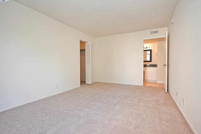 an empty room with closet and mirror