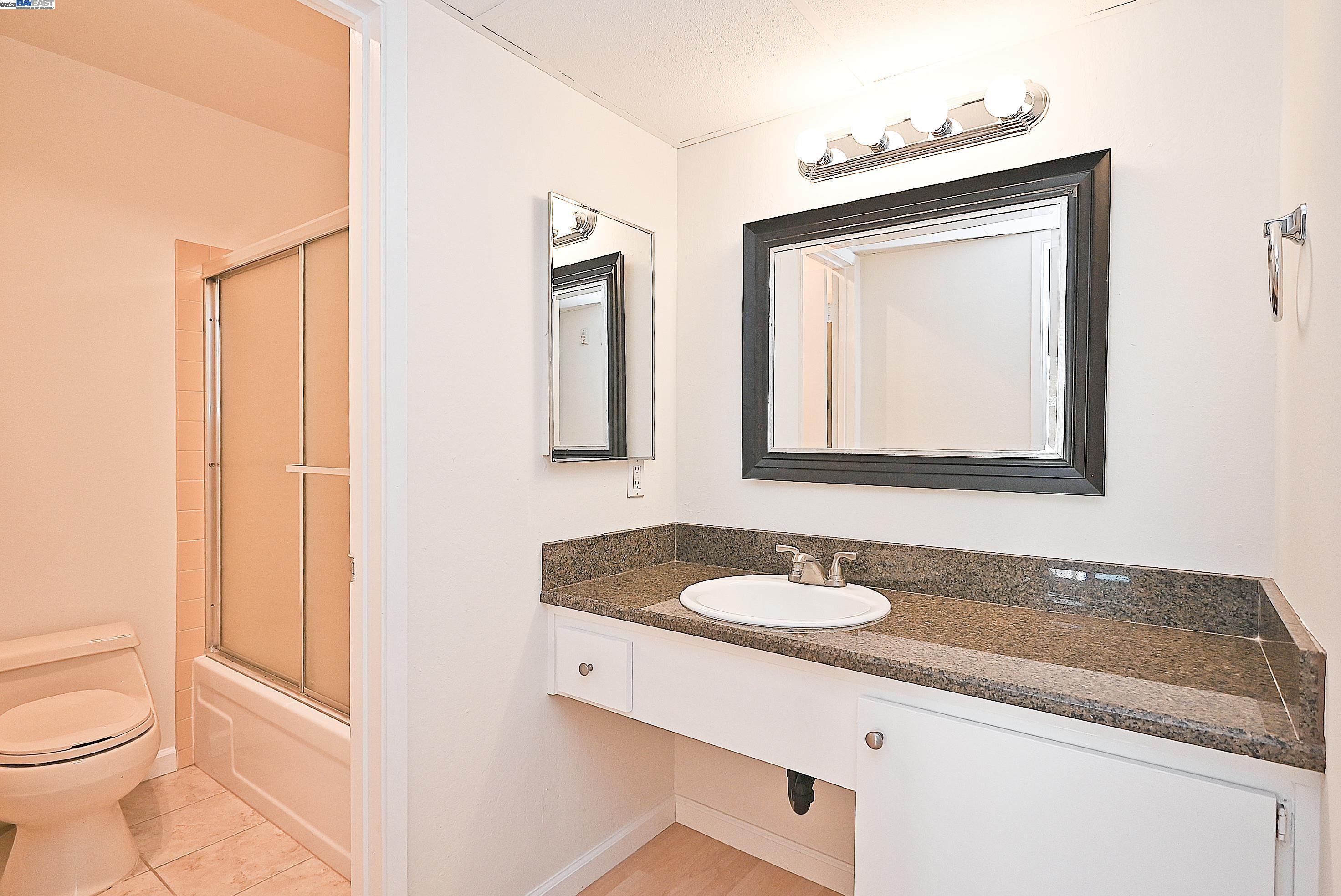 320 North Civic Drive, Unit 307 Walnut Creek, CA 94596 - Photo 22 of 37 a bathroom with a granite countertop sink and a mirror