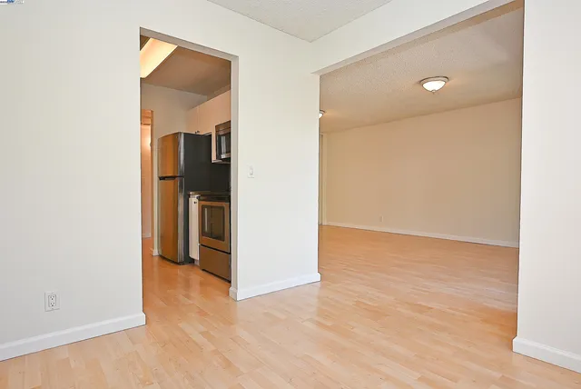 an empty room with wooden floor and a bathroom