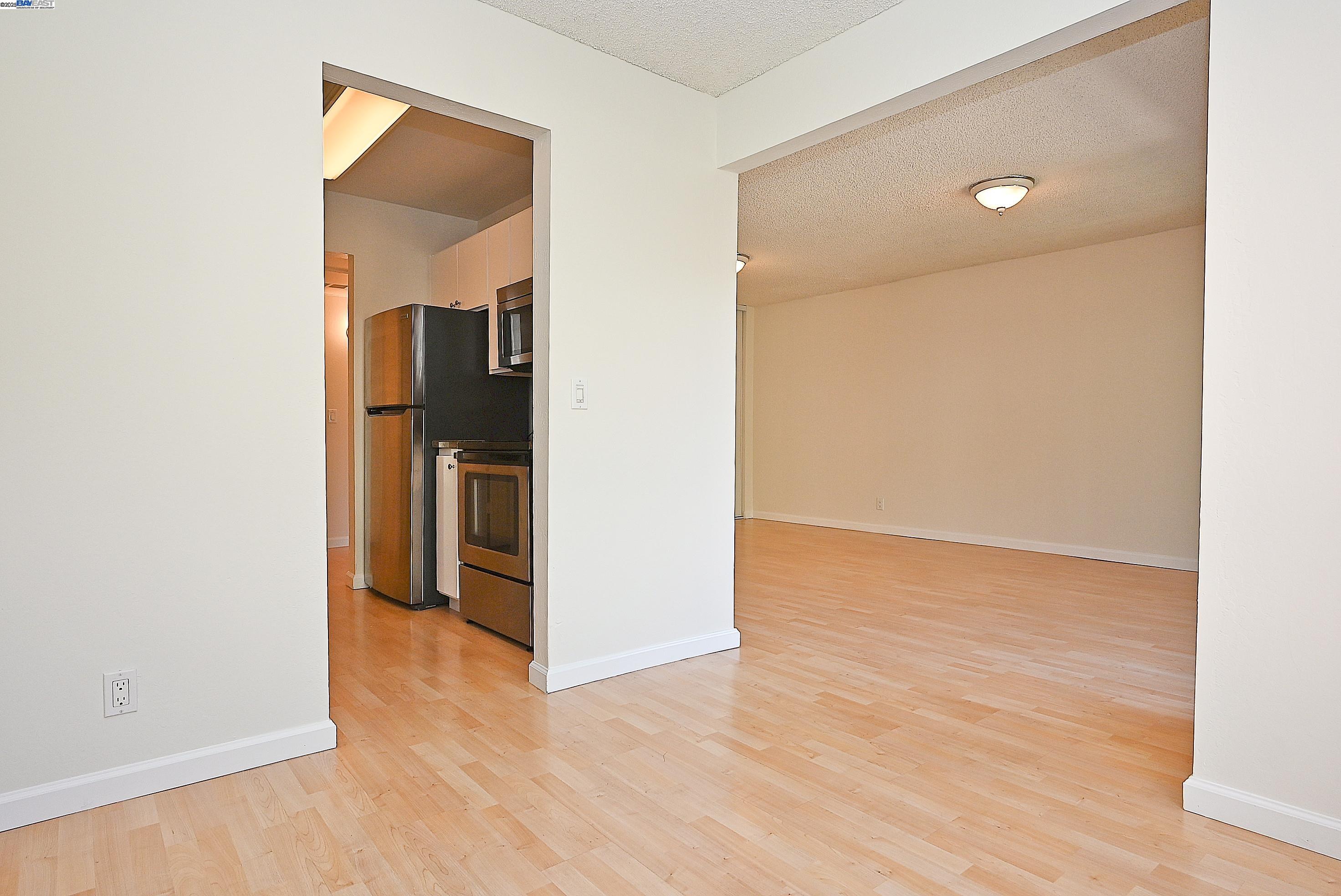 320 North Civic Drive, Unit 307 Walnut Creek, CA 94596 - Photo 7 of 37 an empty room with wooden floor and a bathroom