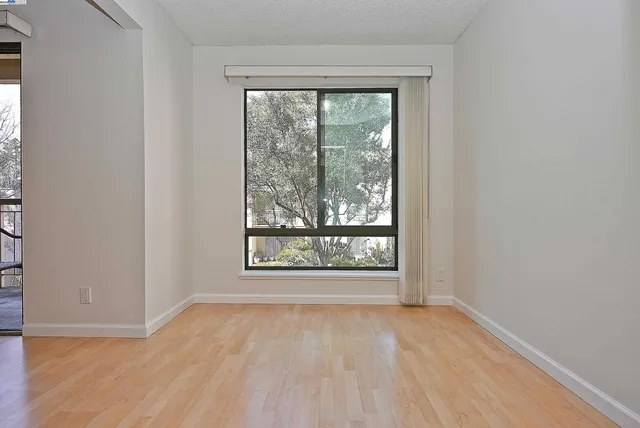 an empty room with wooden floor and a window