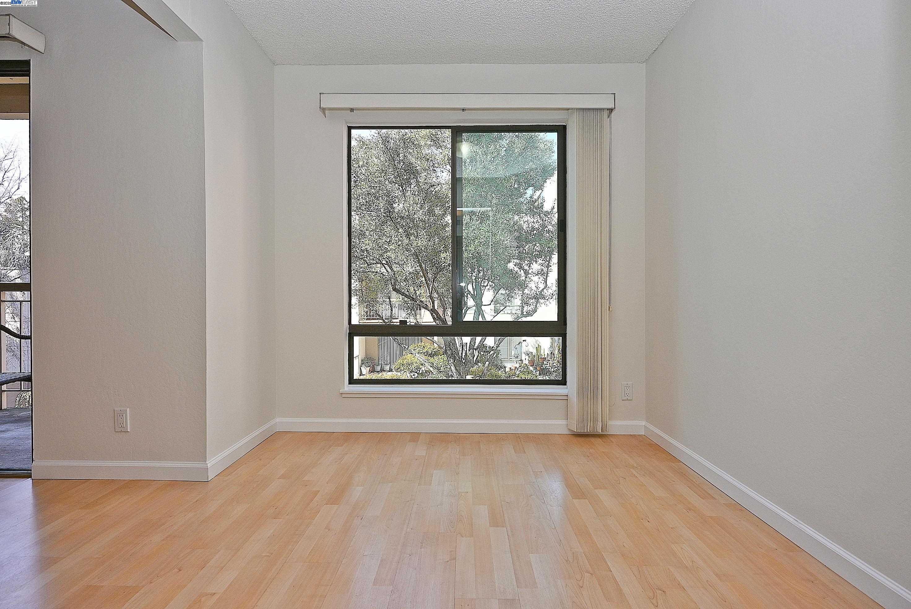 320 North Civic Drive, Unit 307 Walnut Creek, CA 94596 - Photo 8 of 37 an empty room with wooden floor and a window