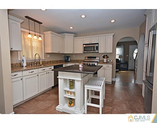 110 Highfield Road Colonia, NJ 07067 - Photo 2 of 23 a kitchen with stainless steel appliances granite countertop a stove a sink a refrigerator and a microwave