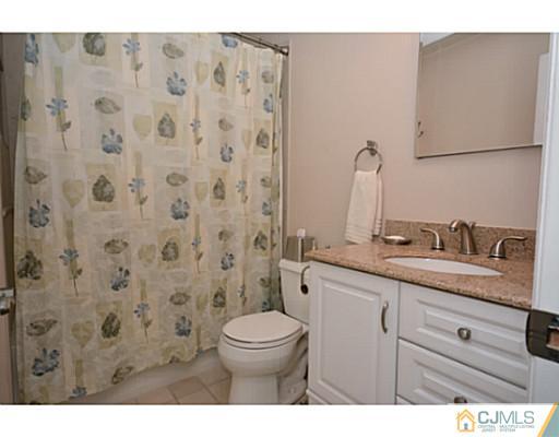 110 Highfield Road Colonia, NJ 07067 - Photo 12 of 23 a bathroom with a granite countertop sink a toilet and a mirror