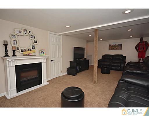 110 Highfield Road Colonia, NJ 07067 - Photo 14 of 23 a living room with furniture a fireplace and flat screen tv