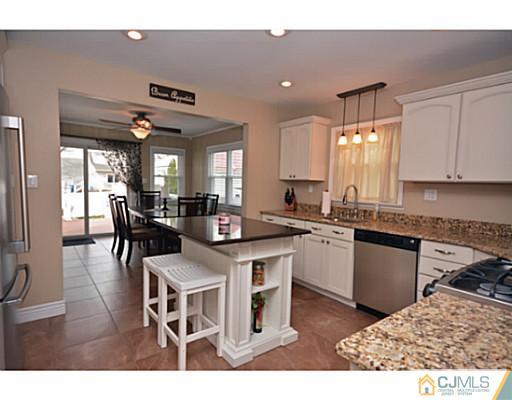 110 Highfield Road Colonia, NJ 07067 - Photo 3 of 23 a kitchen with a dining table chairs and white cabinets