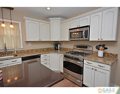 110 Highfield Road Colonia, NJ 07067 - Photo 4 of 23 a kitchen with stainless steel appliances granite countertop a stove a sink and a microwave