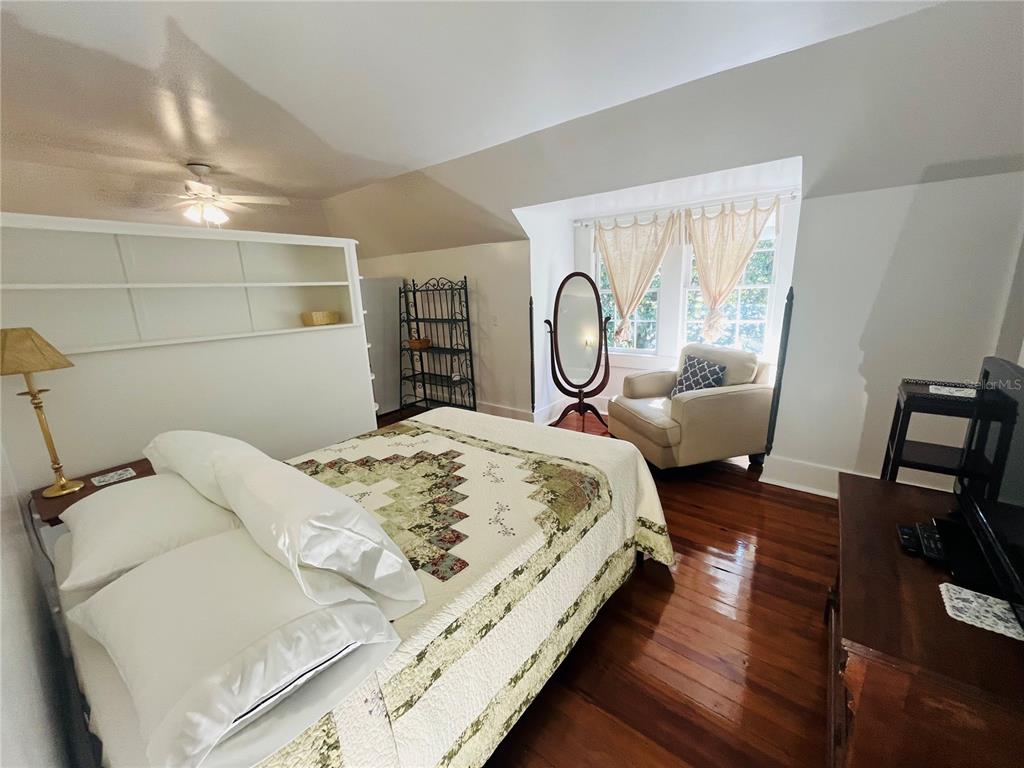 1124 Northwest 4th Street Gainesville, FL 32601 - Photo 12 of 25 a bed sitting in a bedroom next to a window with tv