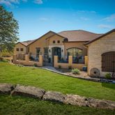 a front view of a house with a yard and trees