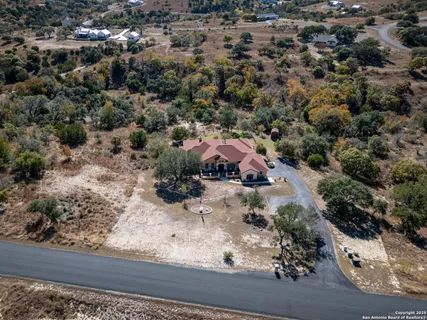 an aerial view of a house with a yard and large tree