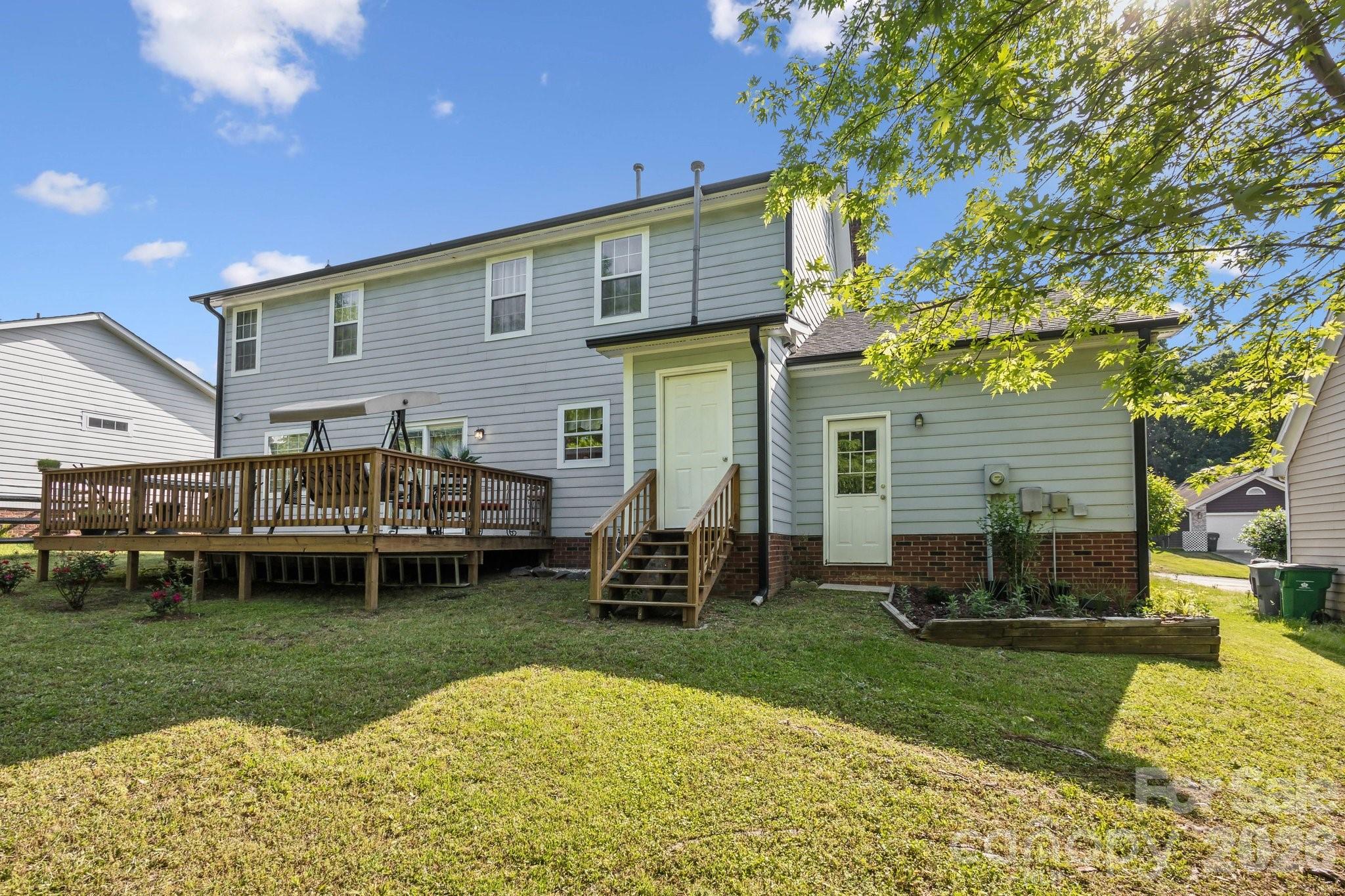 3223 Rheinwood Court Matthews, NC 28105 - Photo 16 of 16 a front view of a house with a garden and chairs
