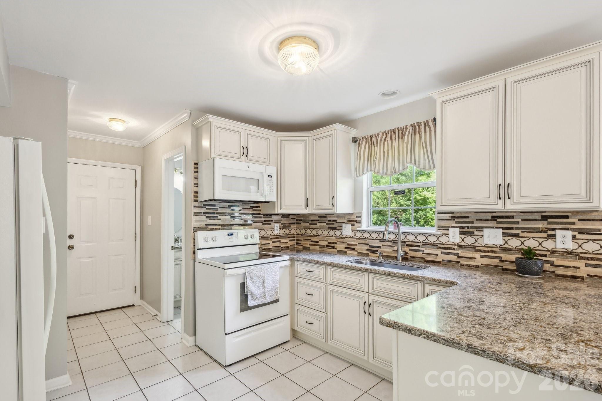 3223 Rheinwood Court Matthews, NC 28105 - Photo 7 of 16 a kitchen with a stove sink and cabinets