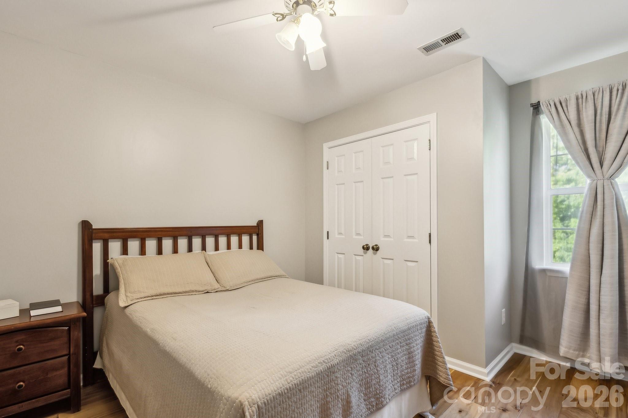 3223 Rheinwood Court Matthews, NC 28105 - Photo 10 of 16 a bedroom with a bed and a chandelier