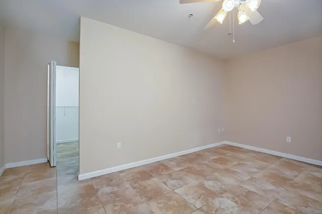 an empty room with a chandelier fan