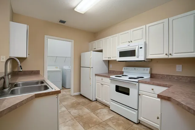 a kitchen with white cabinets and white appliances
