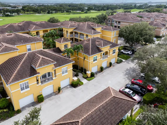 an aerial view of residential houses with outdoor space and parking