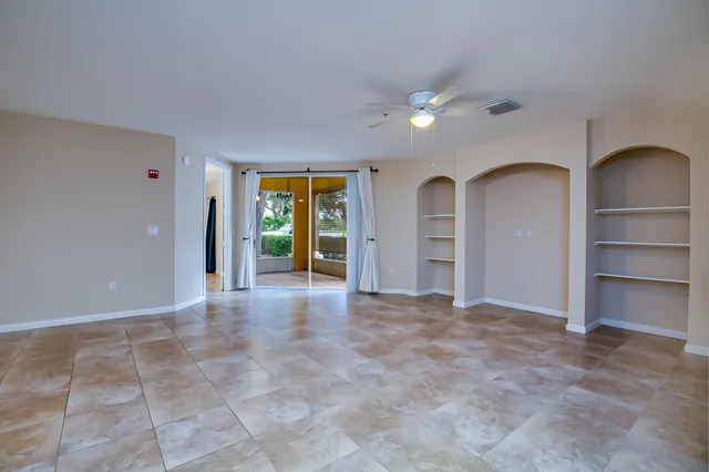 a view of an empty room with closet and a window