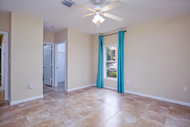 an empty room with closet and a ceiling fan