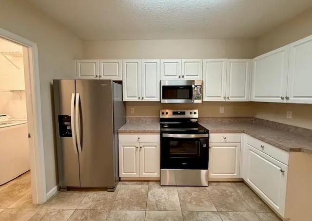 a kitchen with stainless steel appliances a refrigerator stove and microwave