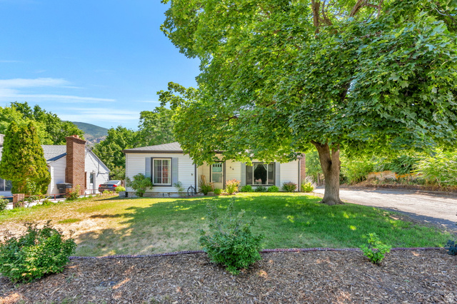 44 North 300 West Springville, UT 84663 - Photo 23 of 24 White exterior featuring a front lawn with mature trees and landscaping