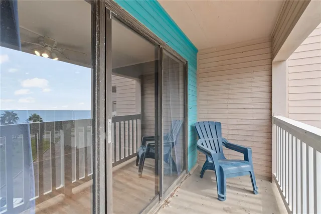 a view of a patio with a table and chairs under an umbrella