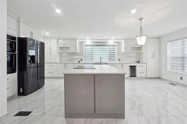 a kitchen with kitchen island a counter top space stainless steel appliances and a window