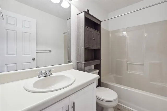 a bathroom with a sink toilet vanity and shower