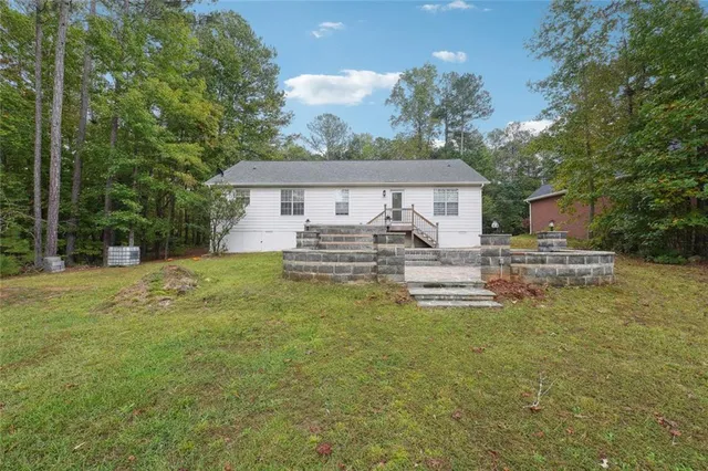 a view of a house with backyard and sitting area
