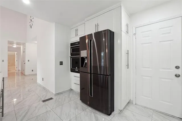 a kitchen with stainless steel appliances a refrigerator and cabinets