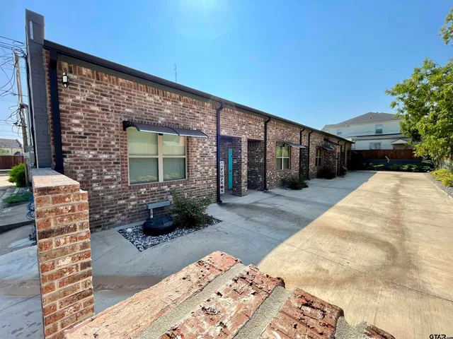 a backyard of a house with potted plants and covered with wooden fence