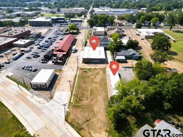 an aerial view of residential houses with outdoor space and parking