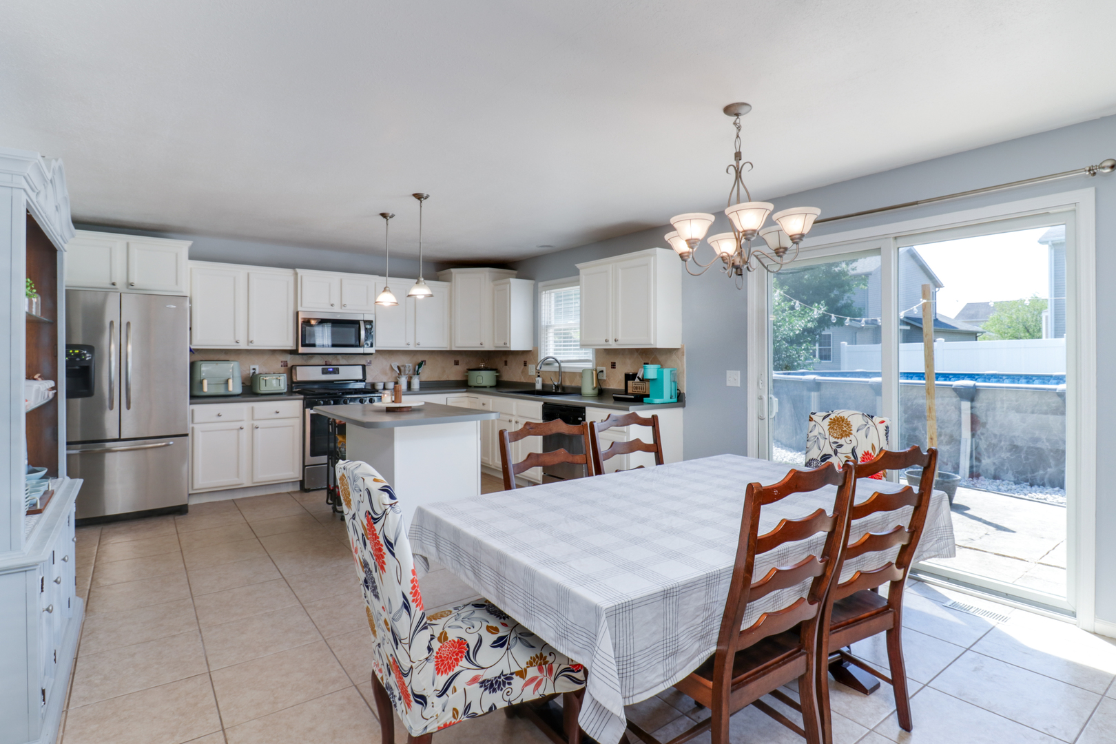 3283 Marimarsh Lane Normal, IL 61761 - Photo 5 of 28 a kitchen with granite countertop a table chairs stainless steel appliances and cabinets