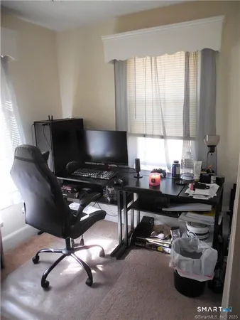 a view of a workspace with furniture and a window