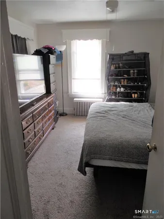 a bedroom with a bed and a television