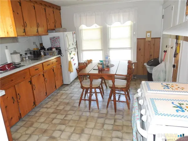 a kitchen with stainless steel appliances kitchen island granite countertop a table chairs and a refrigerator