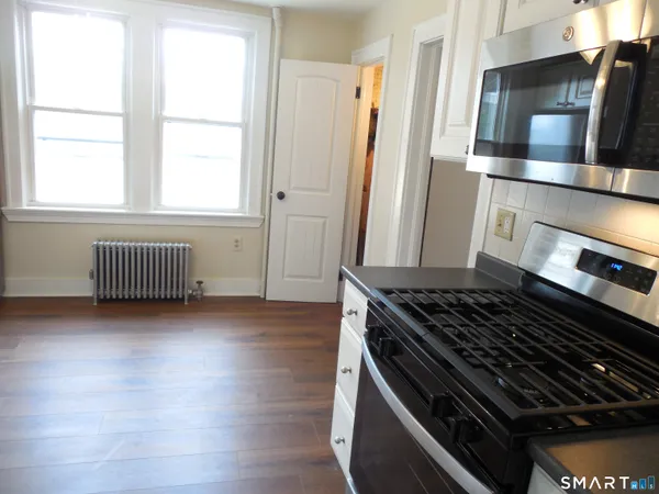 a kitchen with wooden floor and a stove top oven