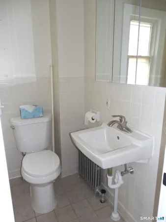 a bathroom with a sink a toilet and a window