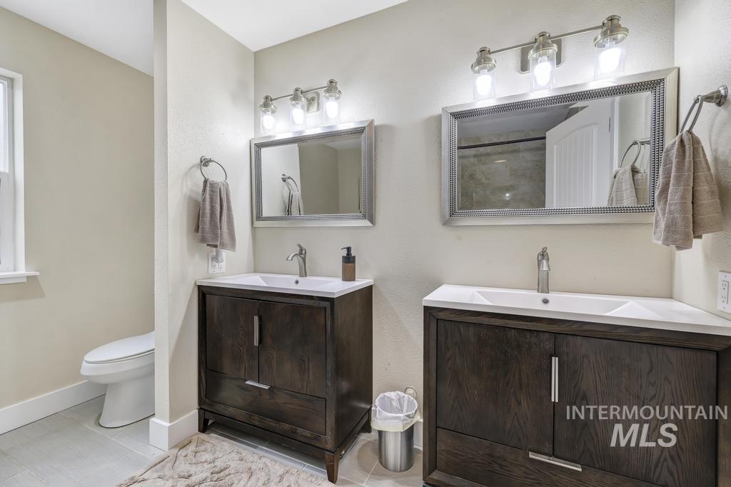 1785 River Road Buhl, ID 83316 - Photo 20 of 41 Bathroom featuring two vanities, a shower, and a textured wall
