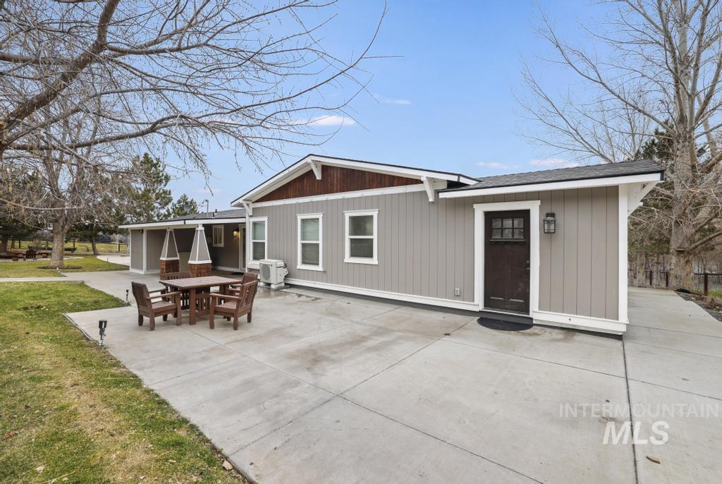 1785 River Road Buhl, ID 83316 - Photo 22 of 41 Back of property with a patio, outdoor dining space, a shingled roof, and a lawn