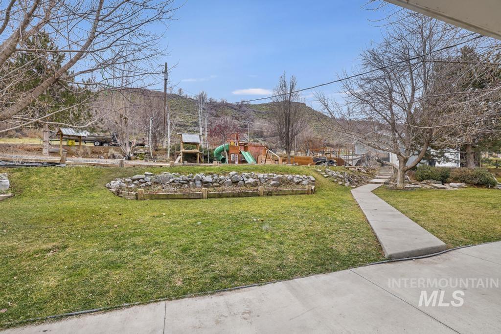 1785 River Road Buhl, ID 83316 - Photo 22 of 41 View of community featuring a playground, a lawn, and a mountain view