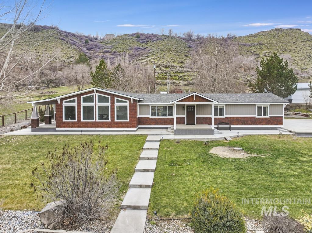 1785 River Road Buhl, ID 83316 - Photo 29 of 41 View of front of home featuring a mountain view, a front lawn, covered porch, and brick siding