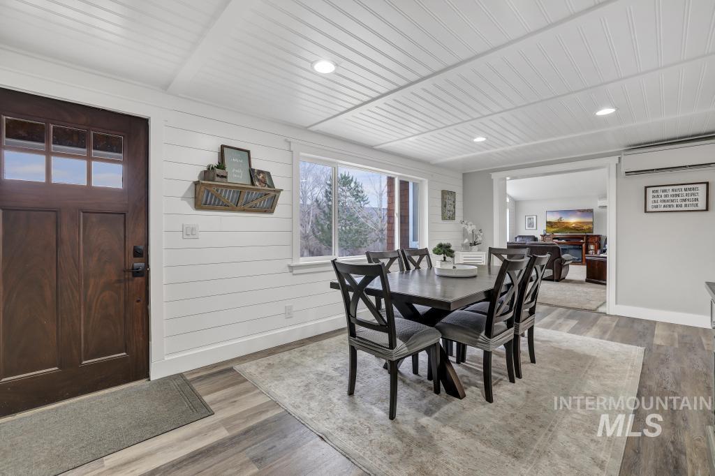 1785 River Road Buhl, ID 83316 - Photo 4 of 41 Dining room featuring light wood finished floors, recessed lighting, an AC wall unit, and wood walls