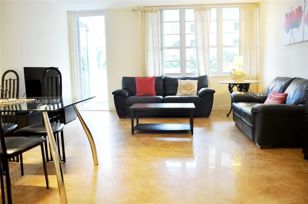 a living room with furniture and a floor to ceiling window