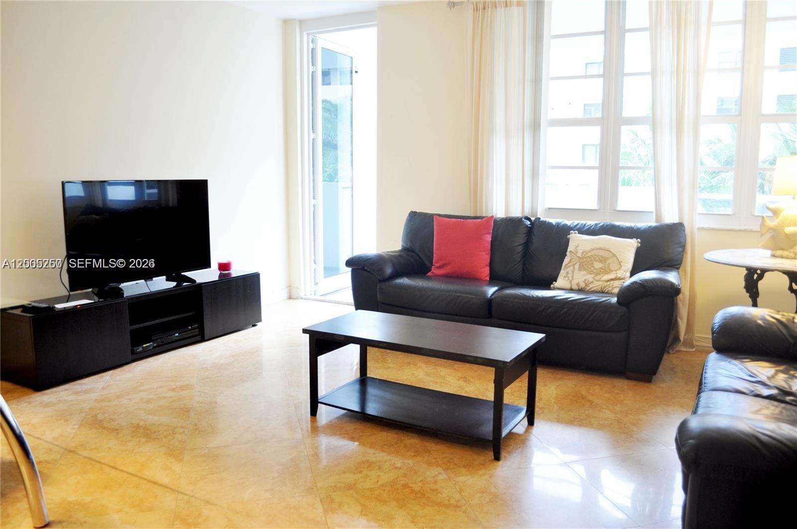 100 Lincoln Road, Unit 534 Miami Beach, FL 33139 - Photo 2 of 15 a living room with furniture and a flat screen tv