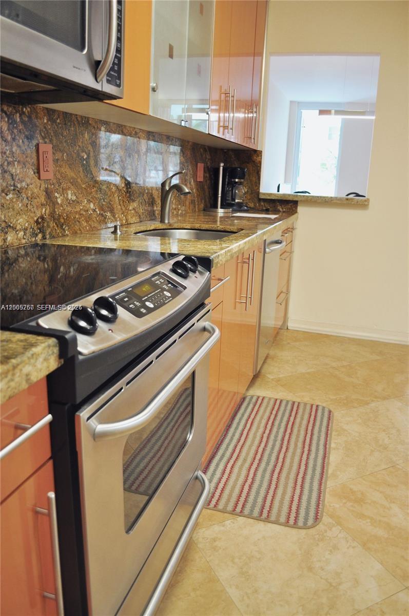 100 Lincoln Road, Unit 534 Miami Beach, FL 33139 - Photo 6 of 15 a kitchen with granite countertop a stove and a sink
