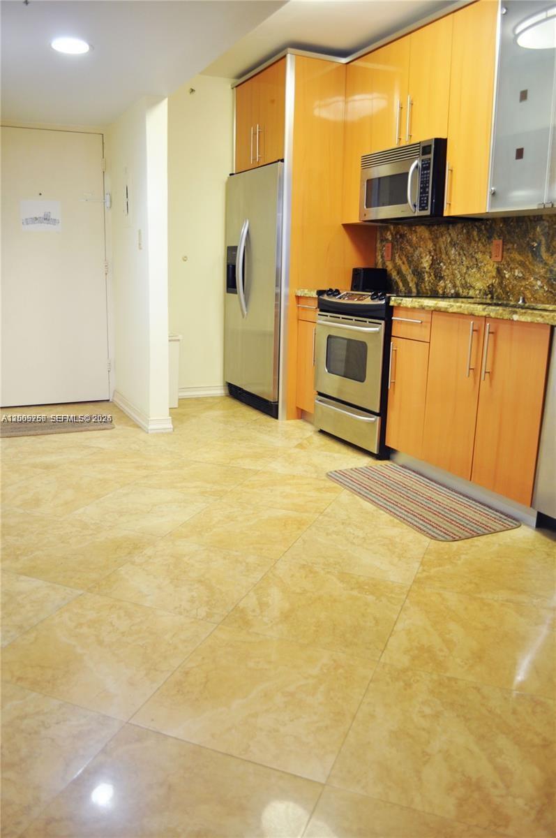 100 Lincoln Road, Unit 534 Miami Beach, FL 33139 - Photo 7 of 15 a view of a kitchen with stainless steel appliances granite countertop a sink refrigerator stove and microwave